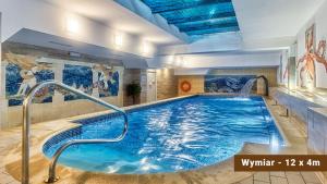 a pool in a hotel room with a swimming pool at St Lukas Medical & SPA in Świeradów-Zdrój