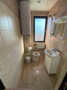 La salle de bains est pourvue de toilettes et d'un lavabo. dans l'établissement Apartments EMIZA, à Samokov