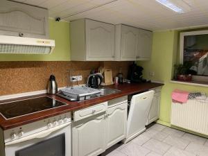 a kitchen with white cabinets and a sink and a stove at City Appartment mit Gartennutzung in Bremen