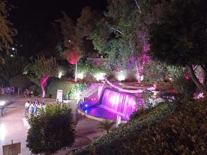 Una fuente en un parque por la noche con luces en Appartement Ain Asserdoun, en Beni Mellal