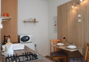 a small kitchen with a stove and a table at Levendula Apartman Pécs in Pécs