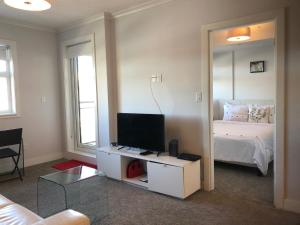 a bedroom with a bed and a tv and a mirror at Amicable, Cozy, High Speed Internet, Sleeps 2 Riverview Downtown Apartment in Calgary