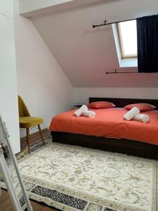 a bedroom with a bed with red sheets and a window at Apartament la casa in Timişoara