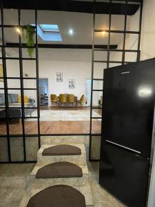 a room with a black refrigerator and a living room at Apartament la casa in Timişoara