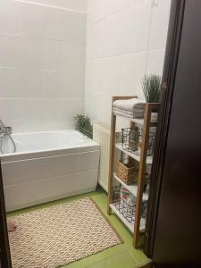 a bathroom with a bath tub and a towel rack at Apartament la casa in Timişoara
