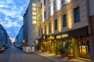 una calle de la ciudad con un edificio con una torre de reloj en Hotel Vienna beim Prater en Viena