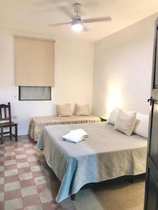 a bedroom with two beds and a ceiling fan at Casa Sarmiento in San Francisco del Monte de Oro +21 photos