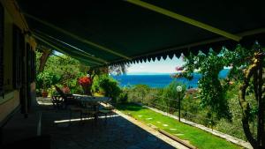 a patio with a table and a view of the ocean at VILLINO BRUNETTO azienda agrituristica in Camogli