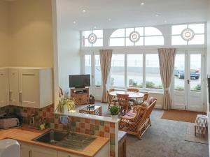 a kitchen and living room with a table and chairs at Seascape in Ramsgate