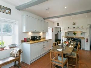 a kitchen and dining room with a table and chairs at Falconer's Lodge in Didlington
