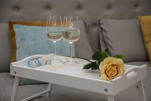 dos copas de vino en una bandeja en una cama en Cuore di Relais e Châteaux 5 STELLE in Bellinzona CITY OF CASTLES -By EasyLife Swiss en Bellinzona
