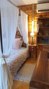 a bedroom with a bed with a canopy and a table at Chambre d'hôtes le petit Ranch in Los Masos