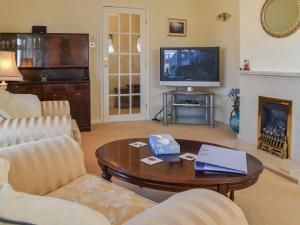 a living room with a coffee table and a television at Squires Bungalow in Gunton