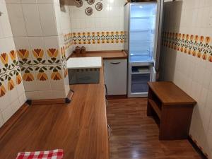 a small kitchen with a refrigerator and wooden floors at Alpestre Trifolium Appartamento Trilo Cervinia CIR 0427 in Breuil-Cervinia