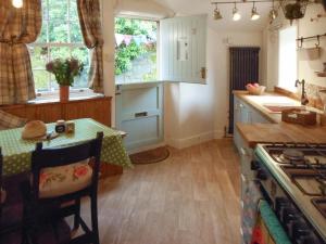 een keuken met een tafel en een keuken met een fornuis bij Birkenhead Cottage in Hebden Bridge