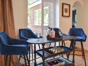 um quarto com cadeiras e uma mesa com garrafas de vinho e copos em Bay House em Canterbury