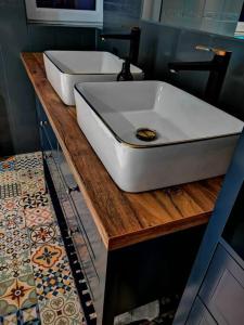 łazienka z dużą białą umywalką na drewnianym blacie w obiekcie Stary Spichlerz w Grudziądzu