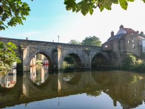 an old stone bridge over a river at 195 Durham Road in Consett