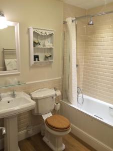 a bathroom with a toilet and a tub and a sink at Trearddur Bay Hotel in Trearddur