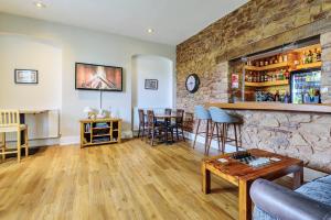 a living room with a stone wall and a bar at The White House Guest House in Williton