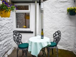 a table with a bottle of wine and two chairs at The Snug in Kirkby Lonsdale