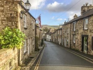 an empty street in a village with stone houses at The Snug in Kirkby Lonsdale