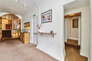 a hallway with white walls and an archway at The White House Guest House in Williton