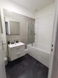 a bathroom with a sink and a shower and a tub at le nid douillet de la gare centre ville de Lens in Lens