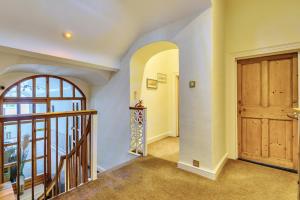 a hallway with a wooden door and a staircase at The White House Guest House in Williton