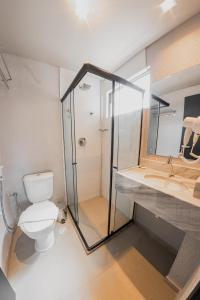 a bathroom with a toilet and a shower and a sink at Saint Patrick Grand Hotel in Maceió