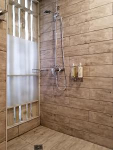 y baño con ducha y pared de madera. en Hotel Costanera en Puerto Natales