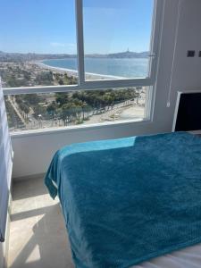 a bedroom with a view of the ocean from a window at Depto Marina Costa a pasos de ENJOY in Coquimbo