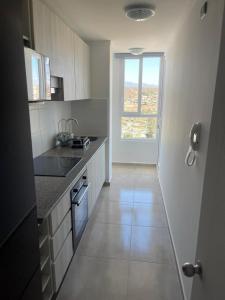 a kitchen with a sink and a window at Depto Marina Costa a pasos de ENJOY in Coquimbo
