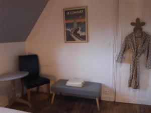 een kamer met een tafel, een stoel en een foto bij Chambre d'hôtes La Maison du Neuilly in Le Conquet