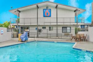 a pool in front of a hotel with a building at Motel 6-El Monte, CA - Los Angeles in El Monte