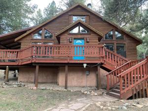 a large wooden house with a large deck at Monroe’s Chateau with Hot Tub in Angel Fire