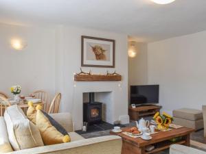 sala de estar con sofá y chimenea en The Cottage Highfield en Rothbury