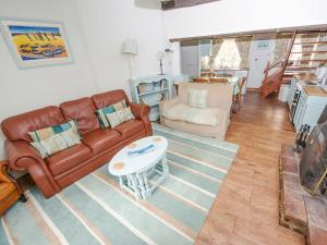 a living room with a couch and a table at Buttercup Cottage - Ukc2847 in Blakeney