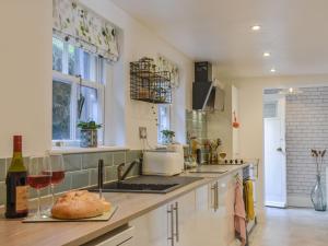 una cocina con una barra con una copa de vino en The Cottage Highfield en Rothbury