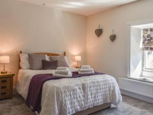 1 dormitorio con 1 cama con toallas en The Cottage Highfield en Rothbury