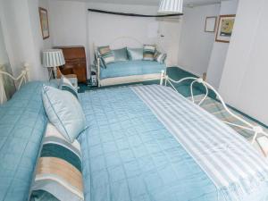 a bedroom with a large bed and a chair at Buttercup Cottage - Ukc2847 in Blakeney