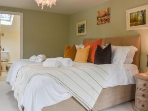 a bedroom with a large bed with towels on it at The Stables in Mudford