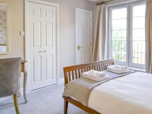 a bedroom with a bed and a desk and a window at Powderhall Brae in Edinburgh