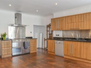 a kitchen with wooden cabinets and stainless steel appliances at Bridge House in Holmfirth