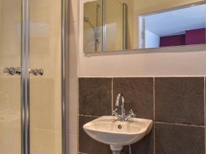 a bathroom with a sink and a shower with a mirror at Bridge House in Holmfirth