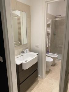 La salle de bains est pourvue d'un lavabo, de toilettes et d'un miroir. dans l'établissement #milanodabere Urban Loft, à Milan