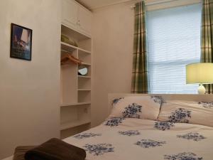a small bedroom with a bed and a window at Flat 2 Beachview - Ukc4220 in Lowestoft