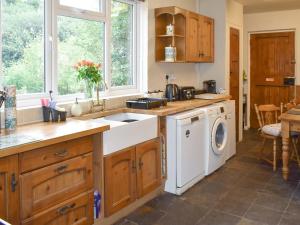 a kitchen with a sink and a washing machine at Oakdene Lodge in Saint Leonards