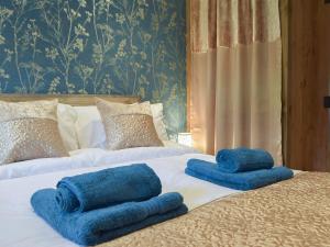 dos toallas azules sentadas encima de dos camas en The Chapel Barn en Llangynllo