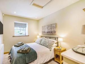 1 dormitorio con cama y escritorio en Drake Cottage en Wilsden